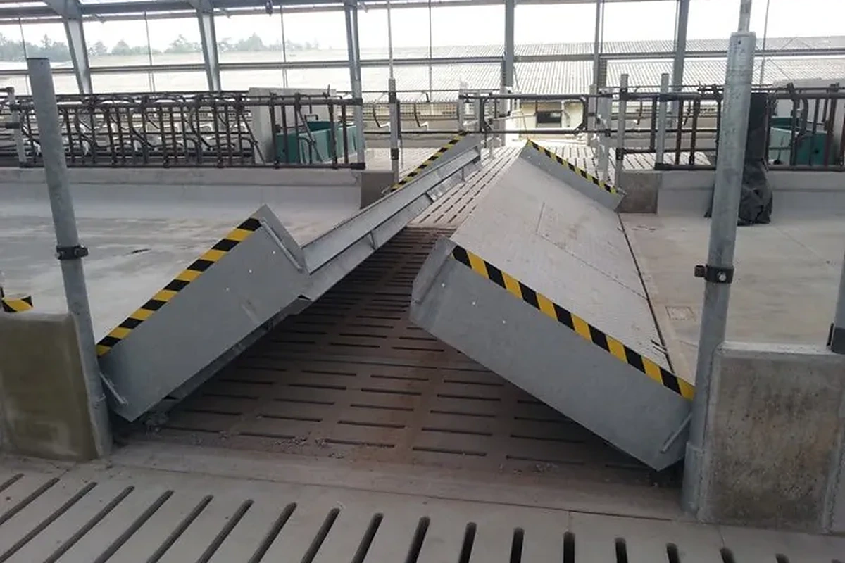 Hydraulická brána přes krmný stůl se dvěma sklopenými částmi a výstražným značením