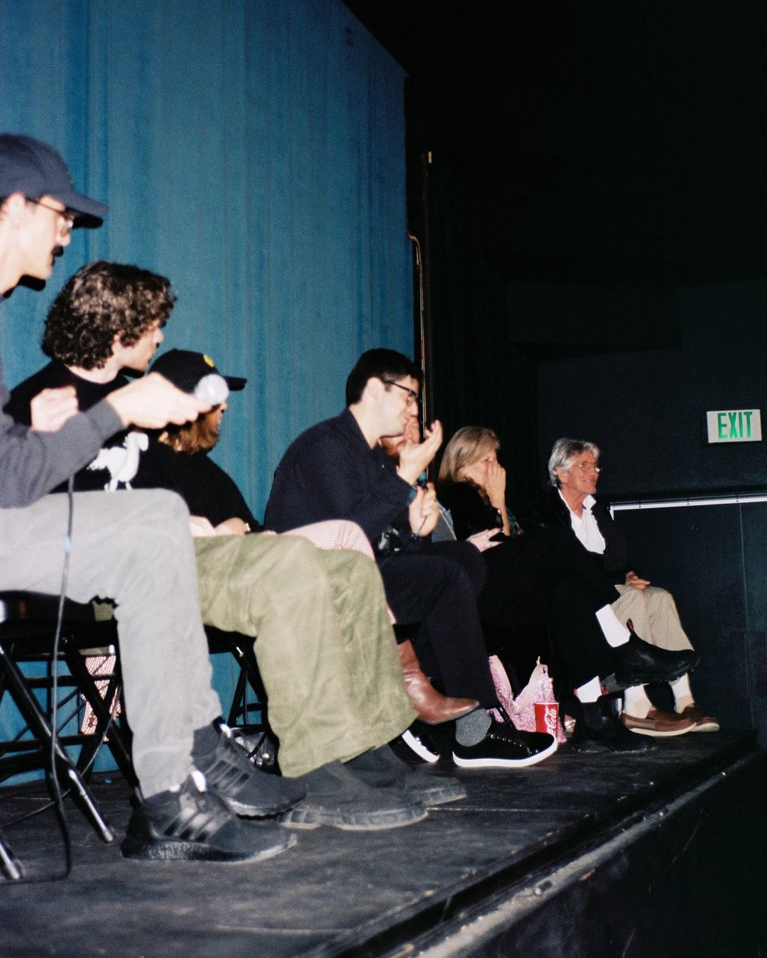 A panel of filmmakers set in an indoor setting. Captured with flash photography. 