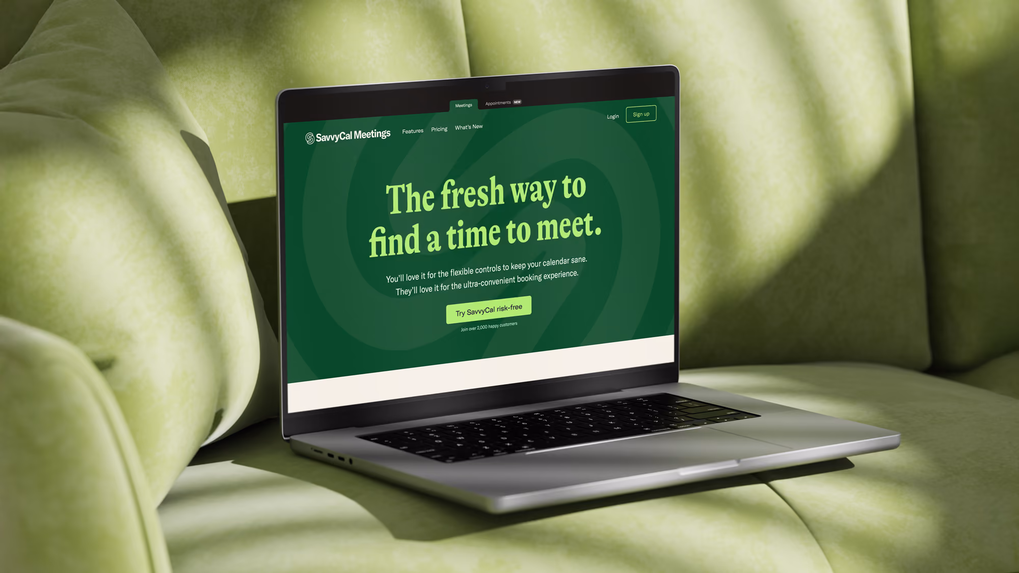 Laptop on green couch displaying SavvyCal Meetings homepage with scheduling app introduction.