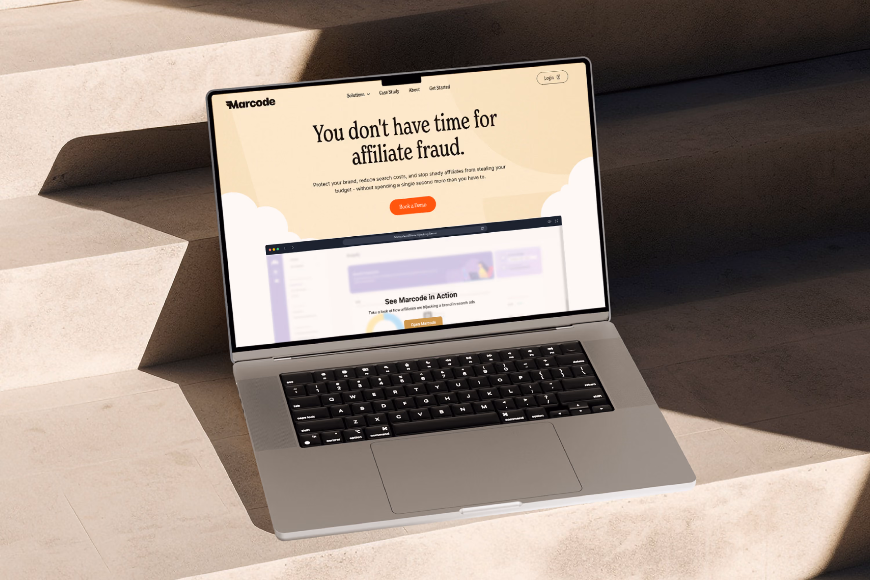 Open laptop on stone steps displaying a webpage with the headline 'You don't have time for affiliate fraud' and a button labeled 'Book a Demo'.