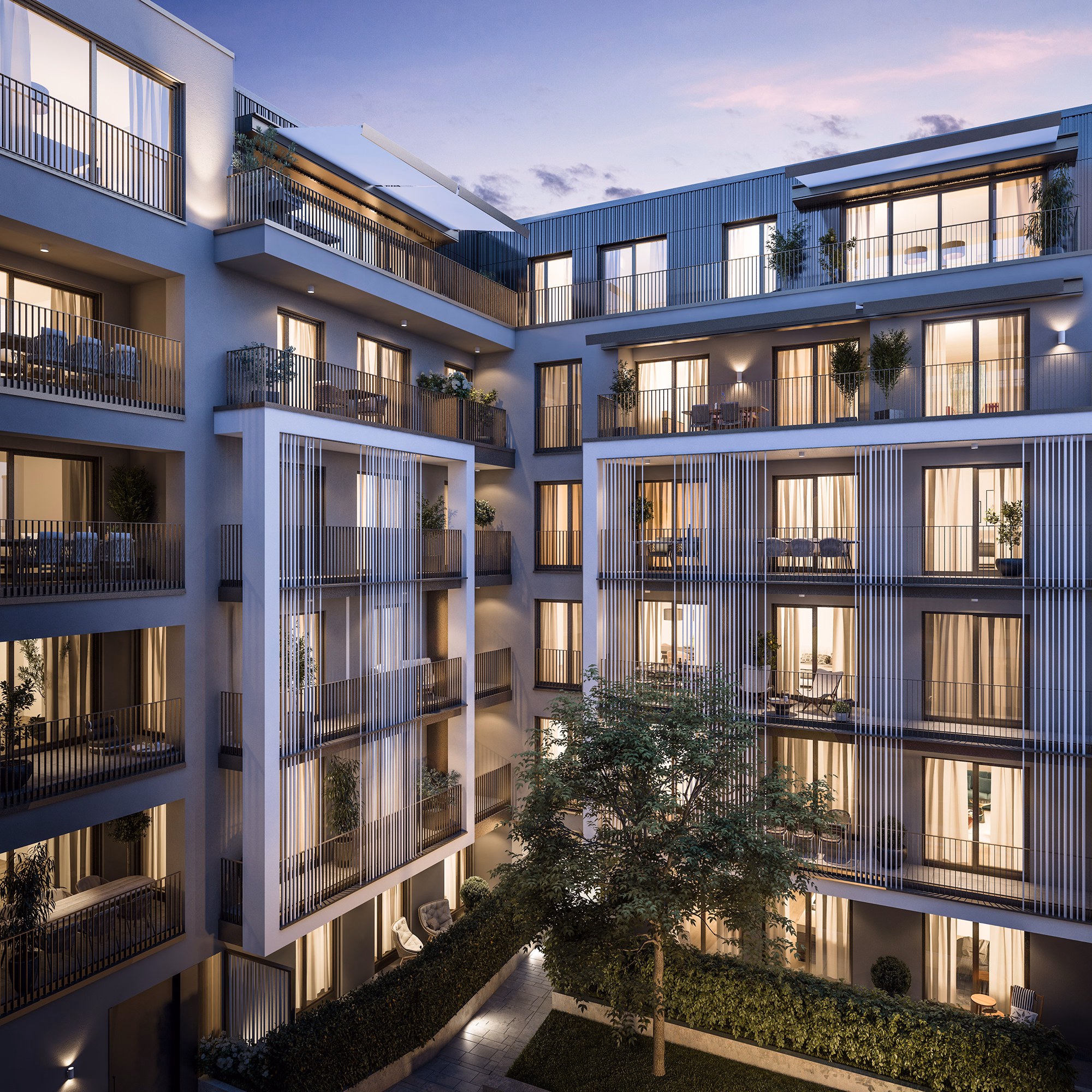 Modern apartment building at dusk with illuminated balconies, large windows, and a central courtyard with a tree and greenery.