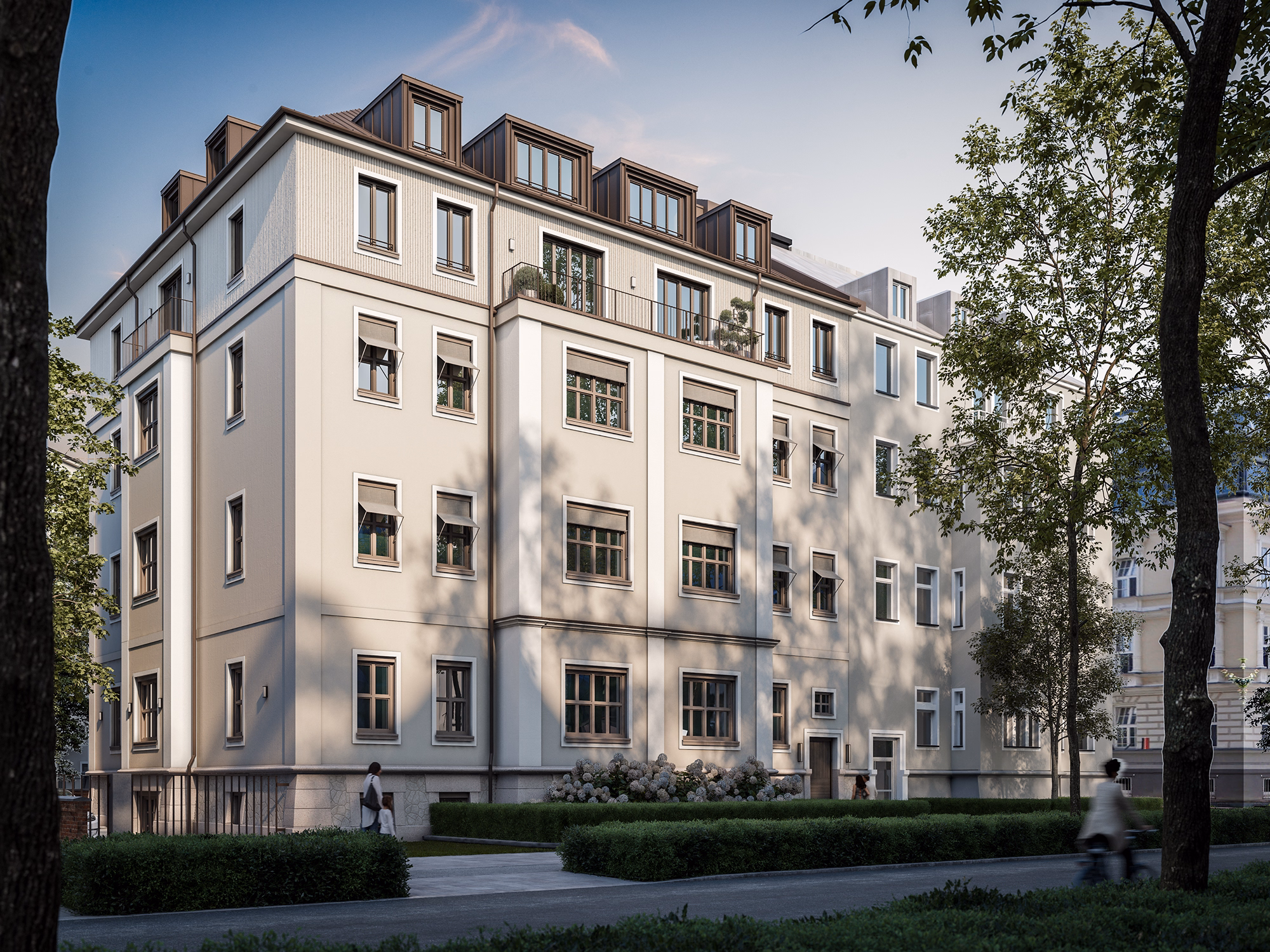 Large white residential building with multiple windows and people walking and cycling nearby under a blue sky with leafy trees.