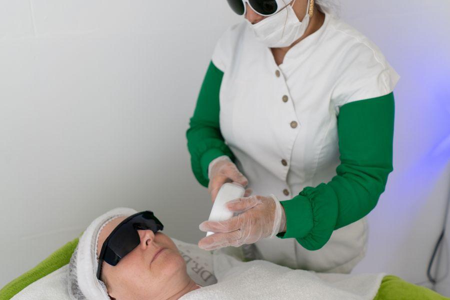 Provider performing a laser treatment on a client wearing protective eyewear