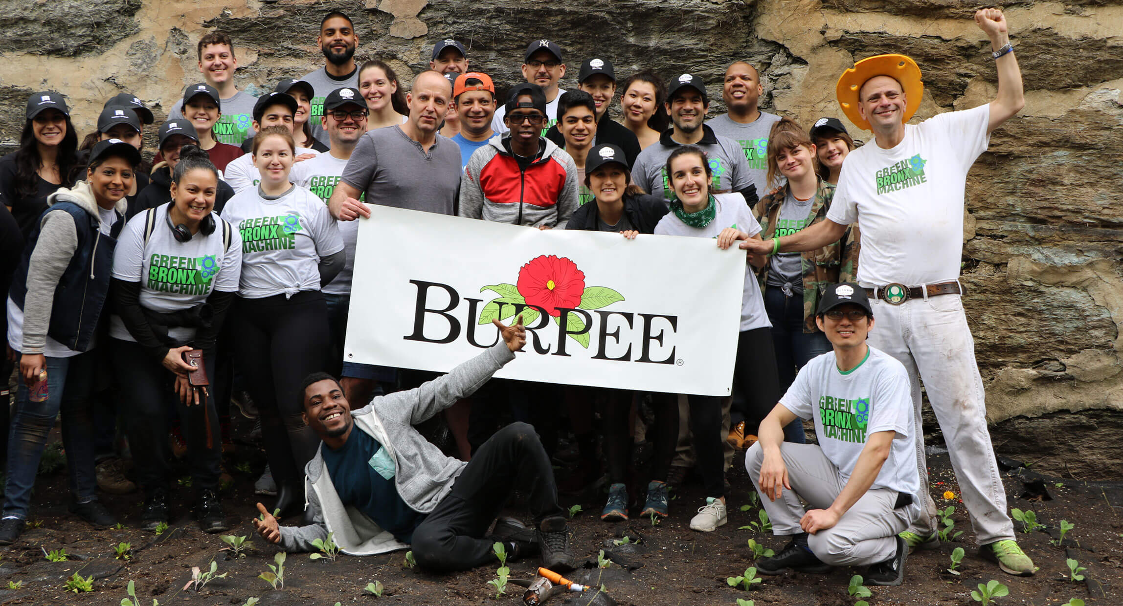 Volunteers holding a Burpee banner at a community planting day