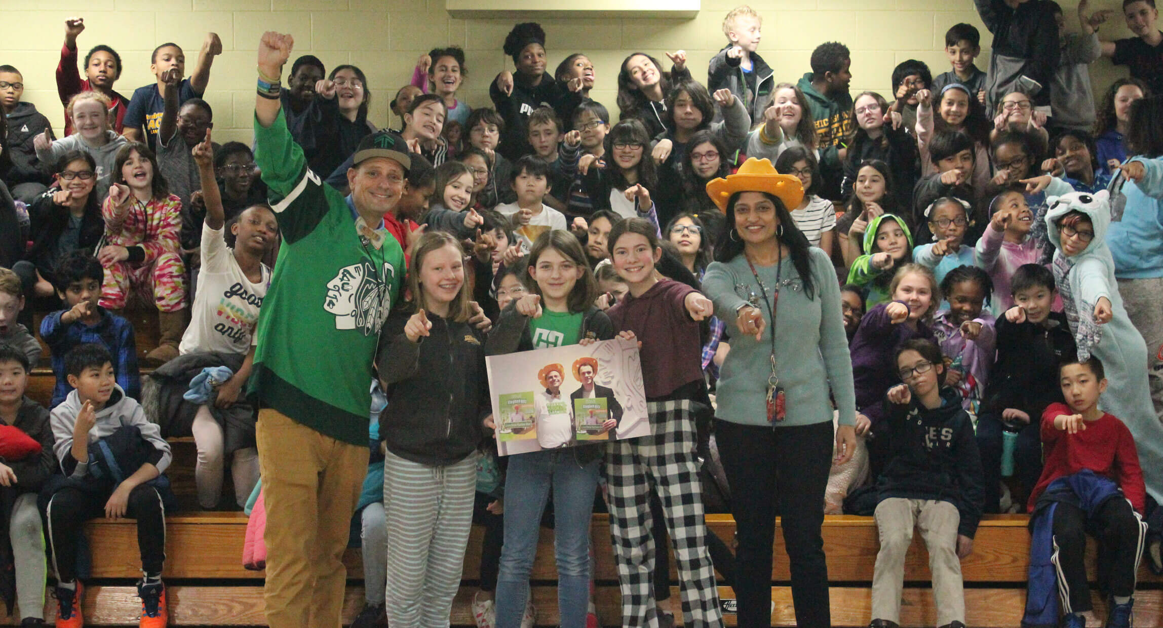 Students packed into a school gym cheering during a Green Bronx Machine assembly