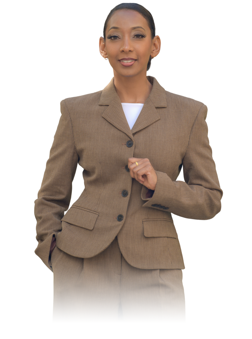 Woman with slicked-back hair wearing a brown checked suit jacket and pants, smiling confidently.
