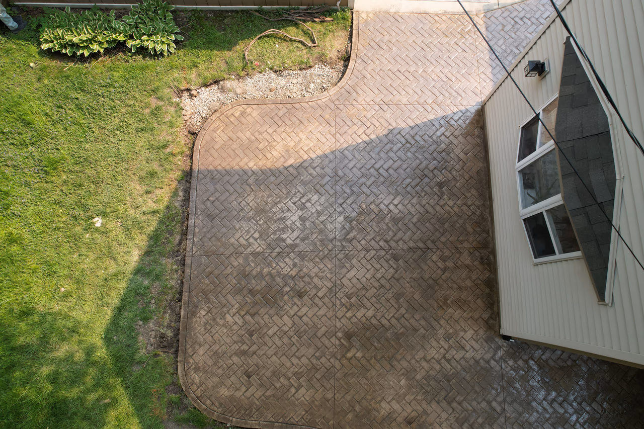 Aerial view of finished herringbone stamped concrete patio with curved edges and scored joints