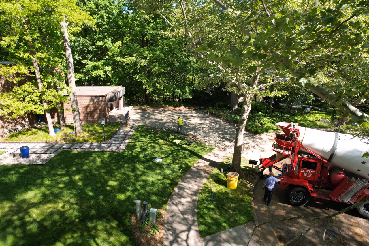 Concrete mixer truck delivering pour for large residential driveway replacement, Grand Rapids MI