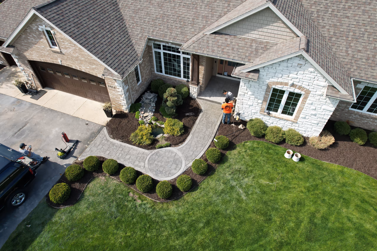 Bird's eye view of completed stamped concrete walkway with circle accent integrated into landscaped front yard with Pro Concrete crew in Caledonia MI