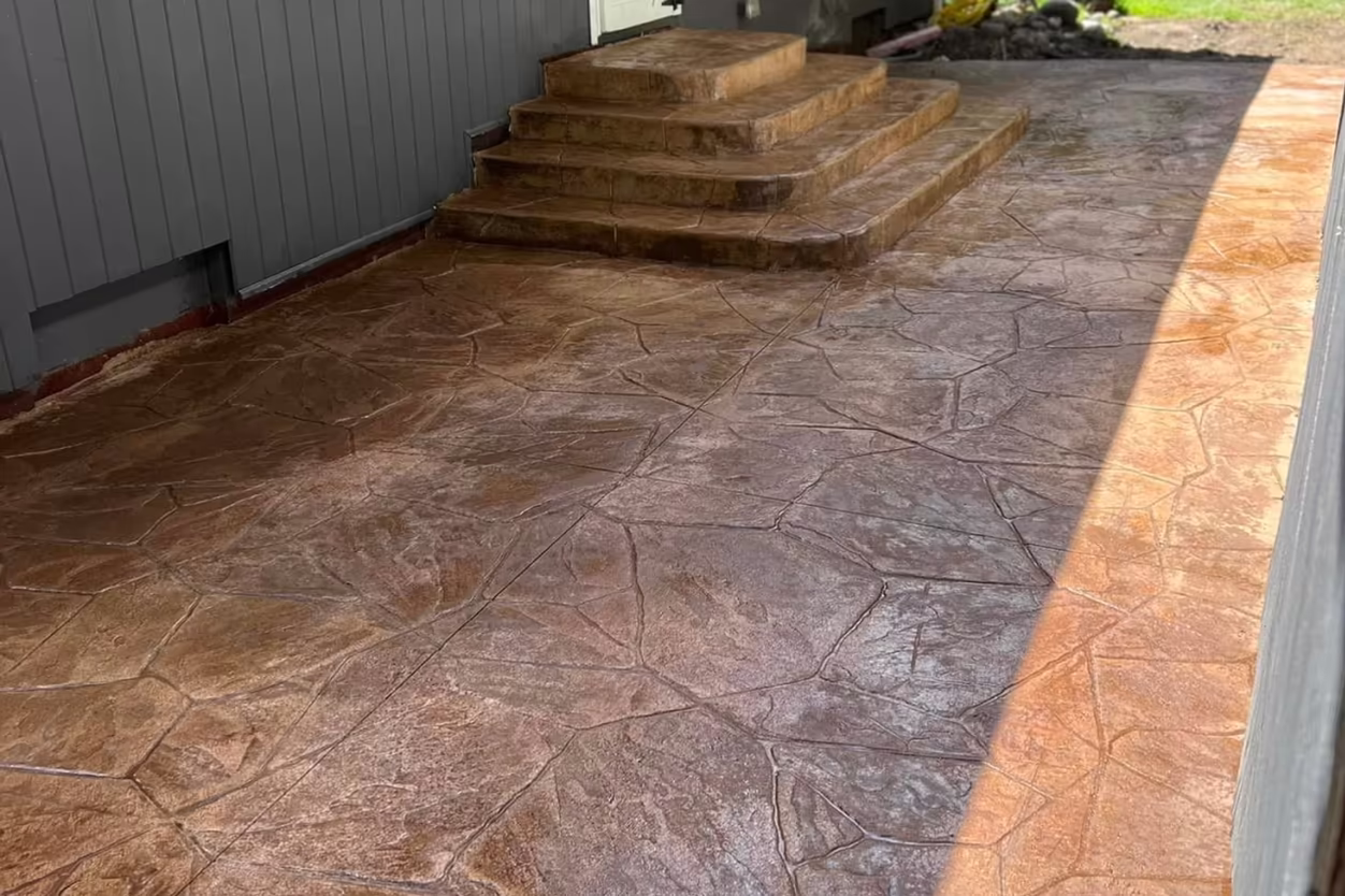 Close view of finished stamped flagstone concrete courtyard with decorative steps and warm brown finish in Grand Rapids MI