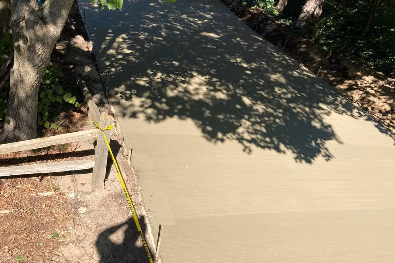 Freshly poured broom finish concrete driveway curing behind detached garage in Grand Rapids MI