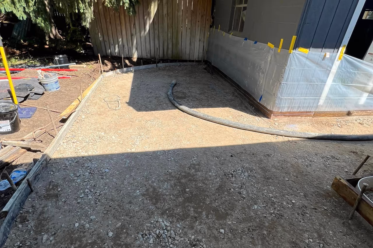 Compacted gravel base and curved forms prepared for stamped concrete walkway pour in Grand Rapids MI