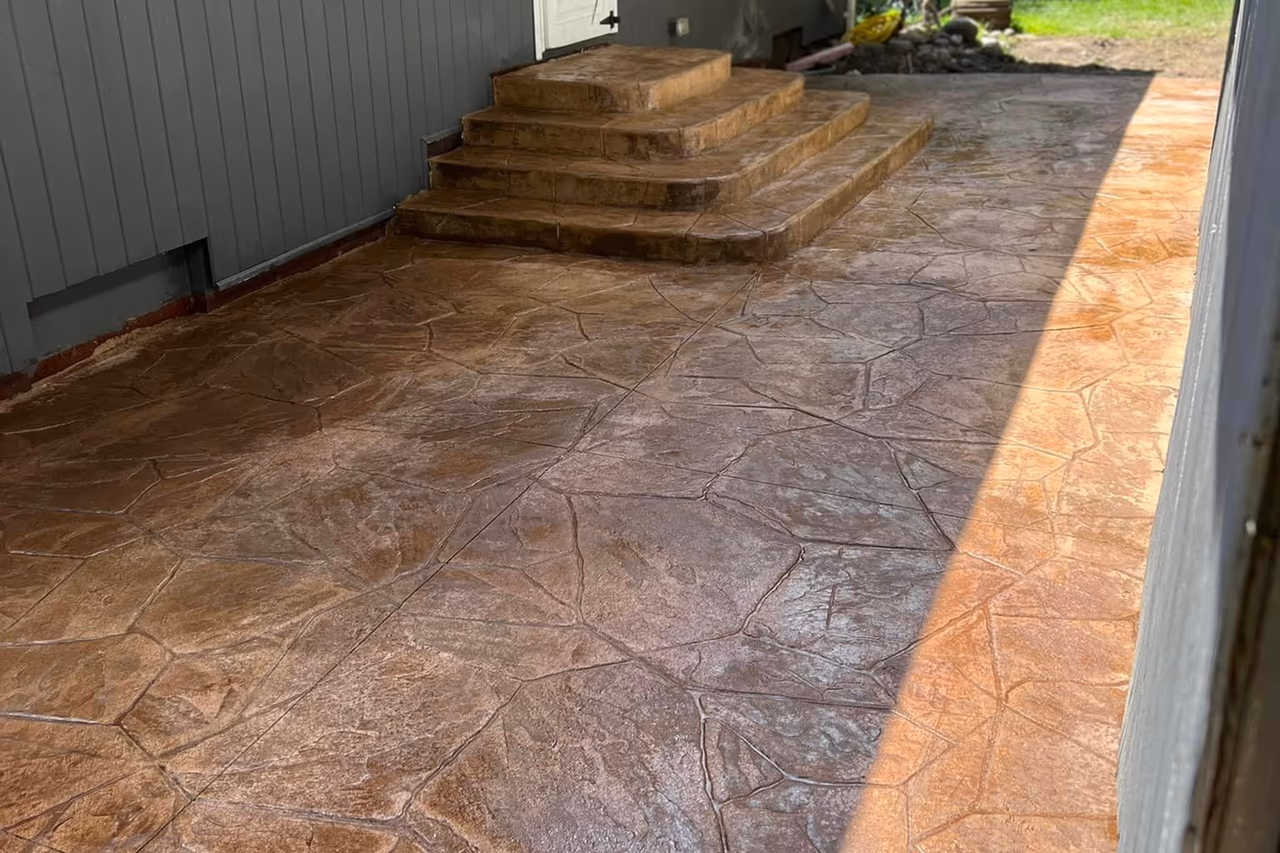 Close view of finished stamped flagstone walkway with multi-tier concrete steps and warm brown finish in Grand Rapids MI