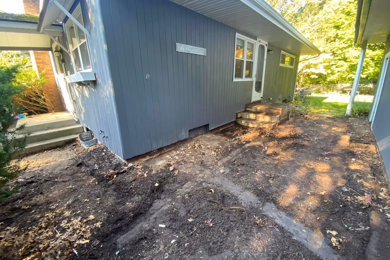 Before photo showing cleared front yard area with old concrete removed ahead of new stamped concrete installation in Grand Rapids MI