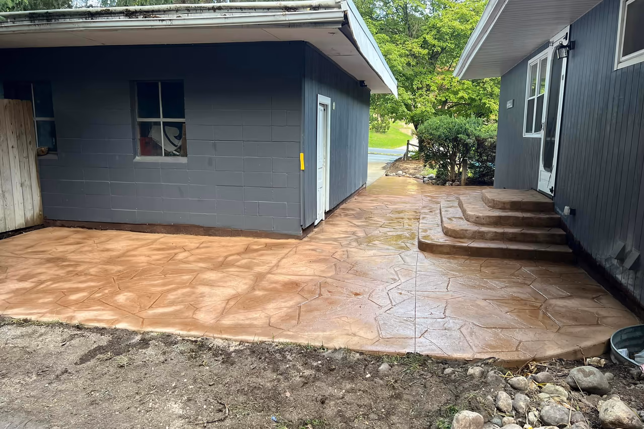 Wide view of completed stamped flagstone concrete surface wrapping around detached garage with steps in Grand Rapids MI