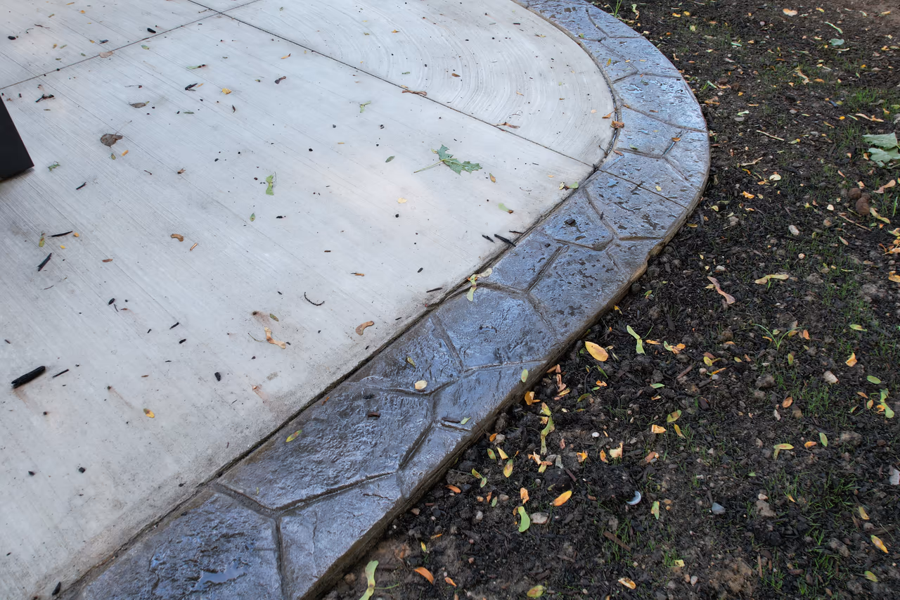 Close aerial view of broom finish concrete patio with curved stamped decorative border in Grand Rapids MI