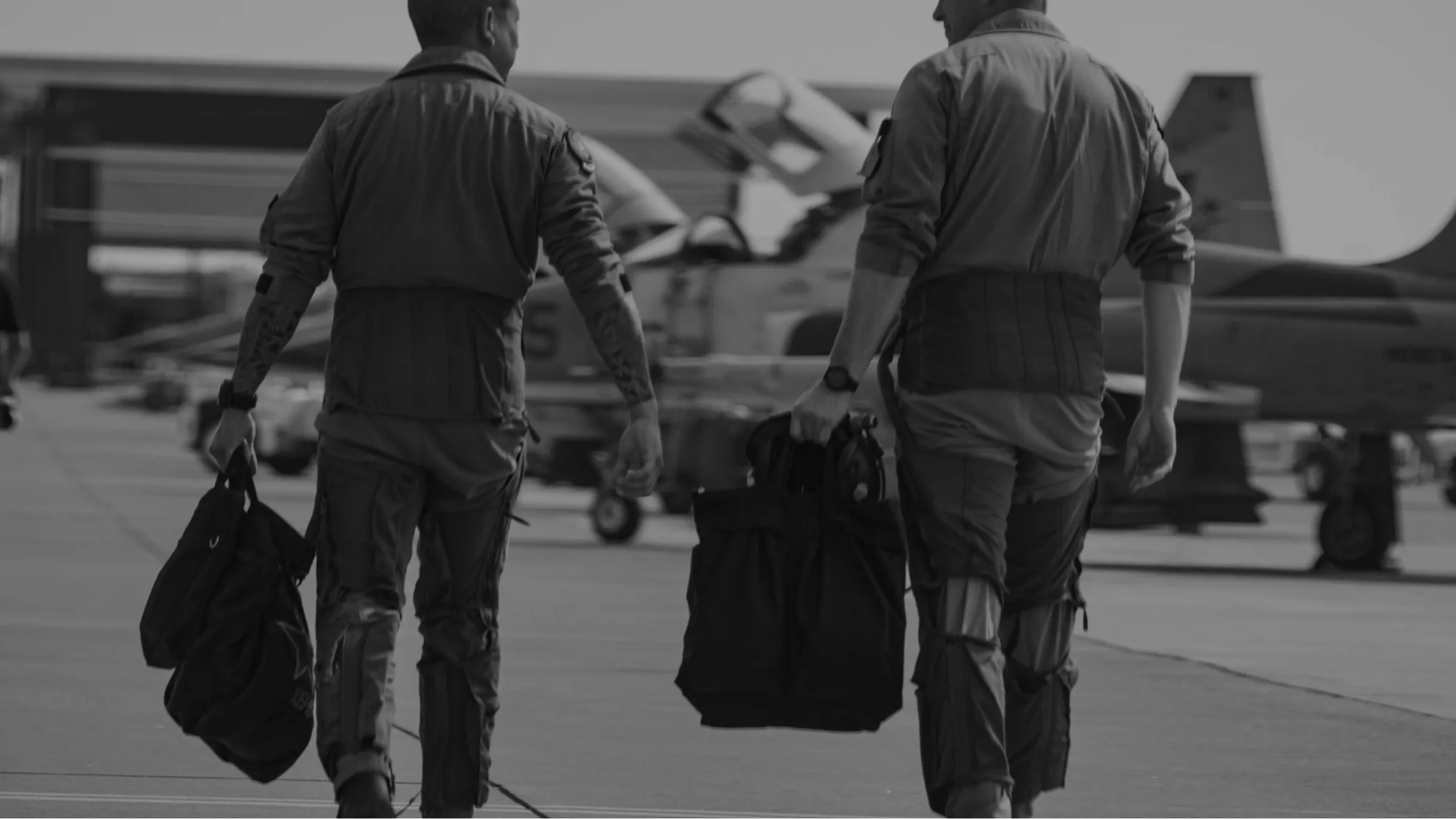 Two pilots walking on tarmac in front of aircraft