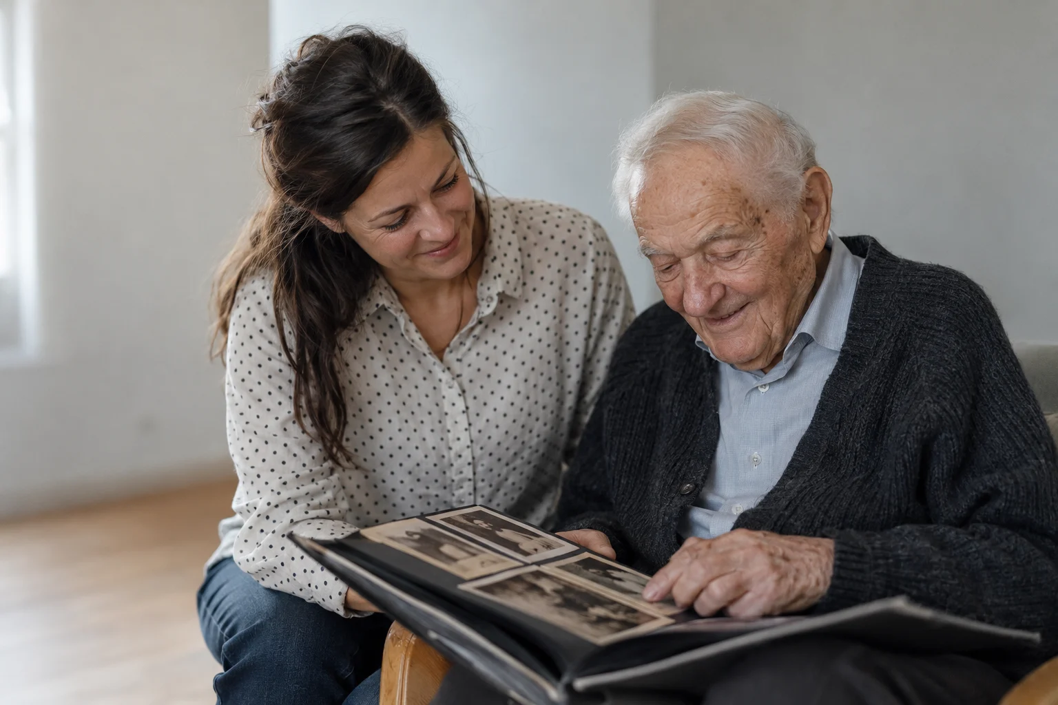 Älterer Mann schaut mit der Therapeutin ein Fotoalbum an