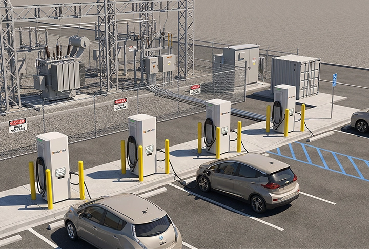 Electric vehicle charging station with four white chargers and two cars parked and charging in designated spots near an electrical substation with warning signs.