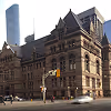 Historic stone building with intricate architecture under clear sky in a city setting.