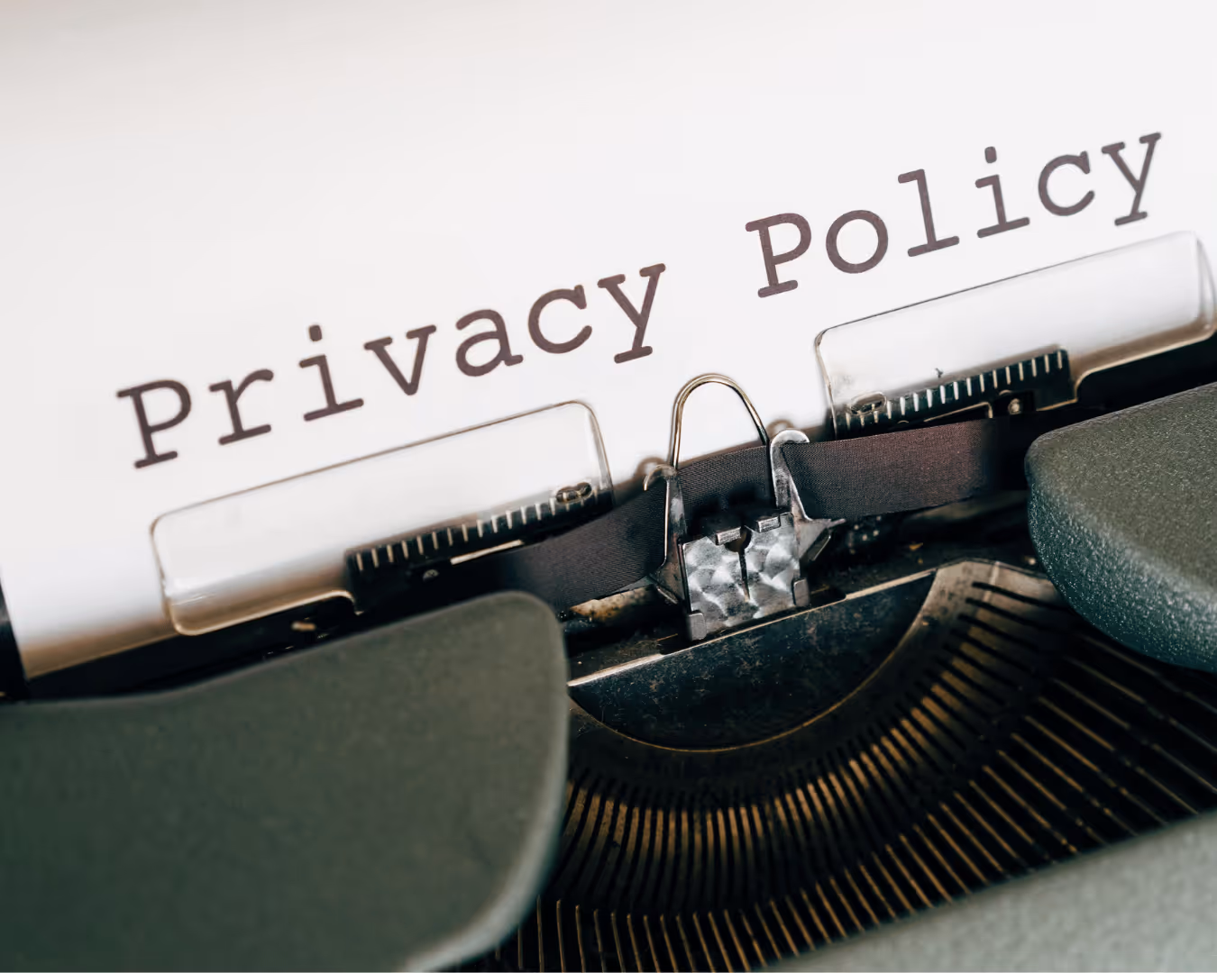 Close-up of a vintage typewriter typing the words Privacy Policy on white paper.