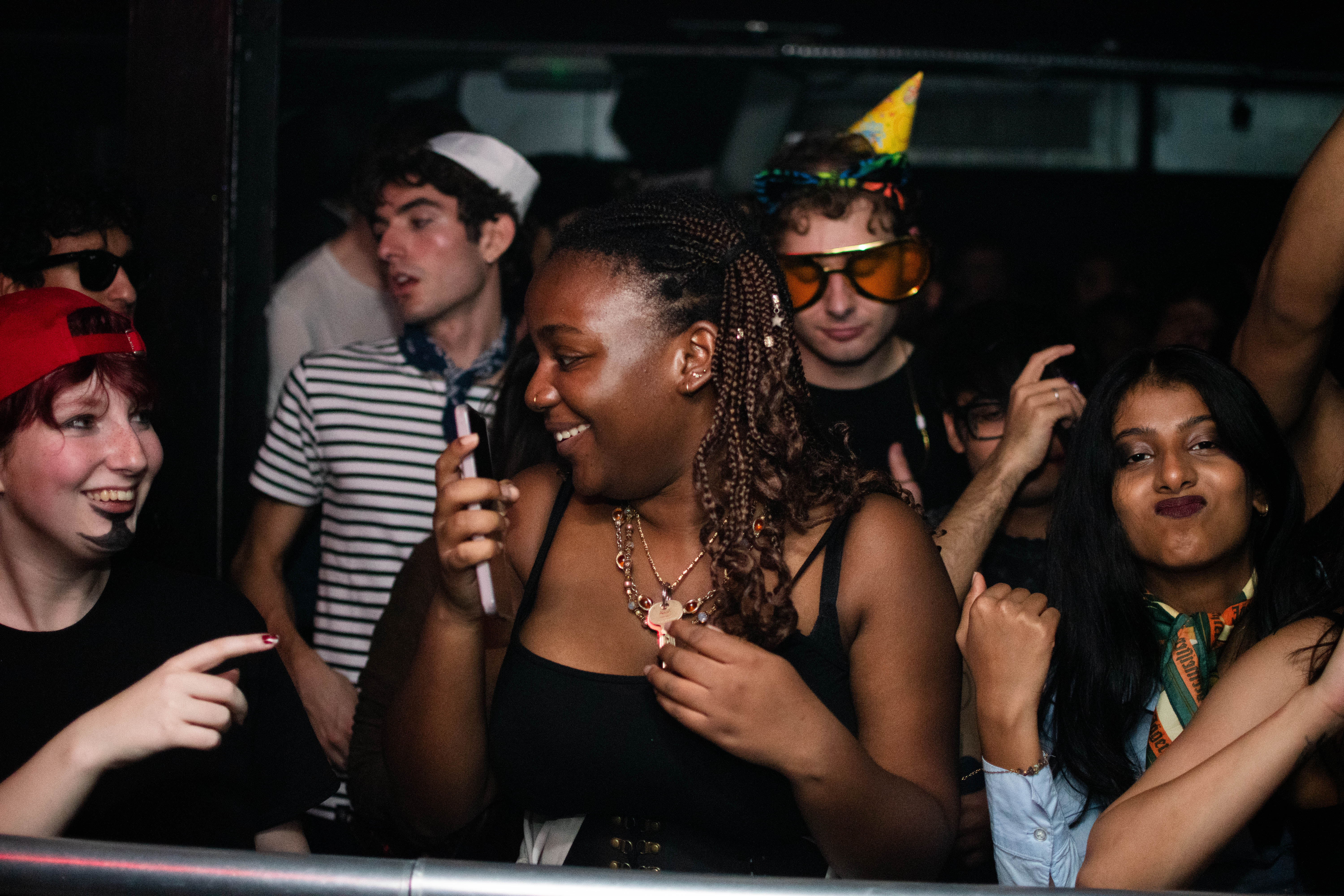 A group of young people dancing and enjoying music at a lively party or club.