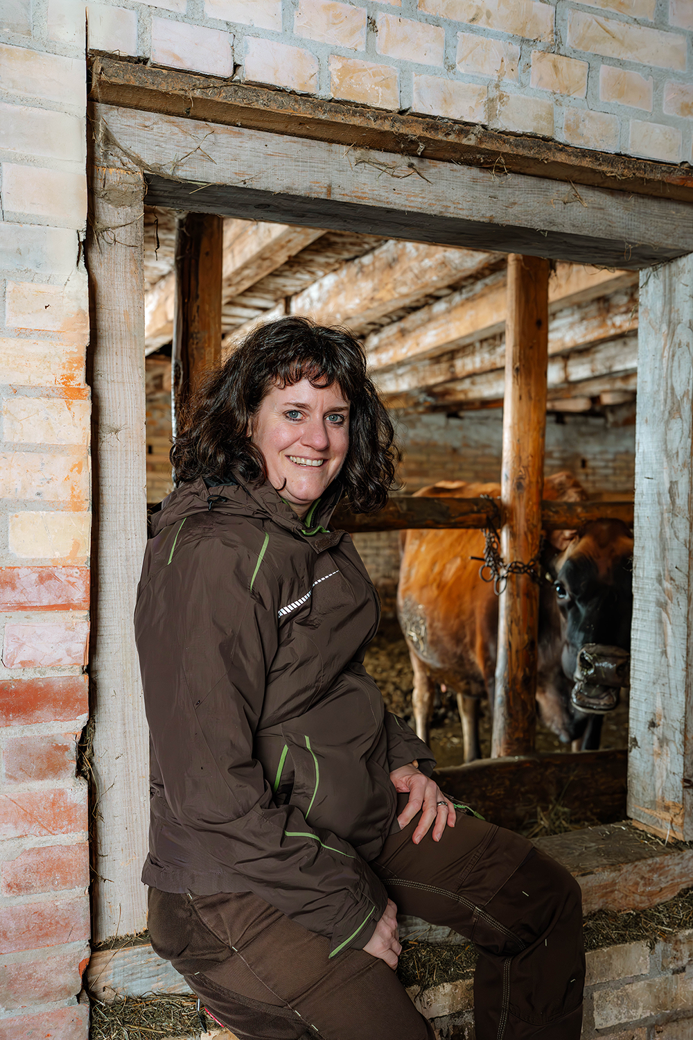 Frau sitzt im Stall