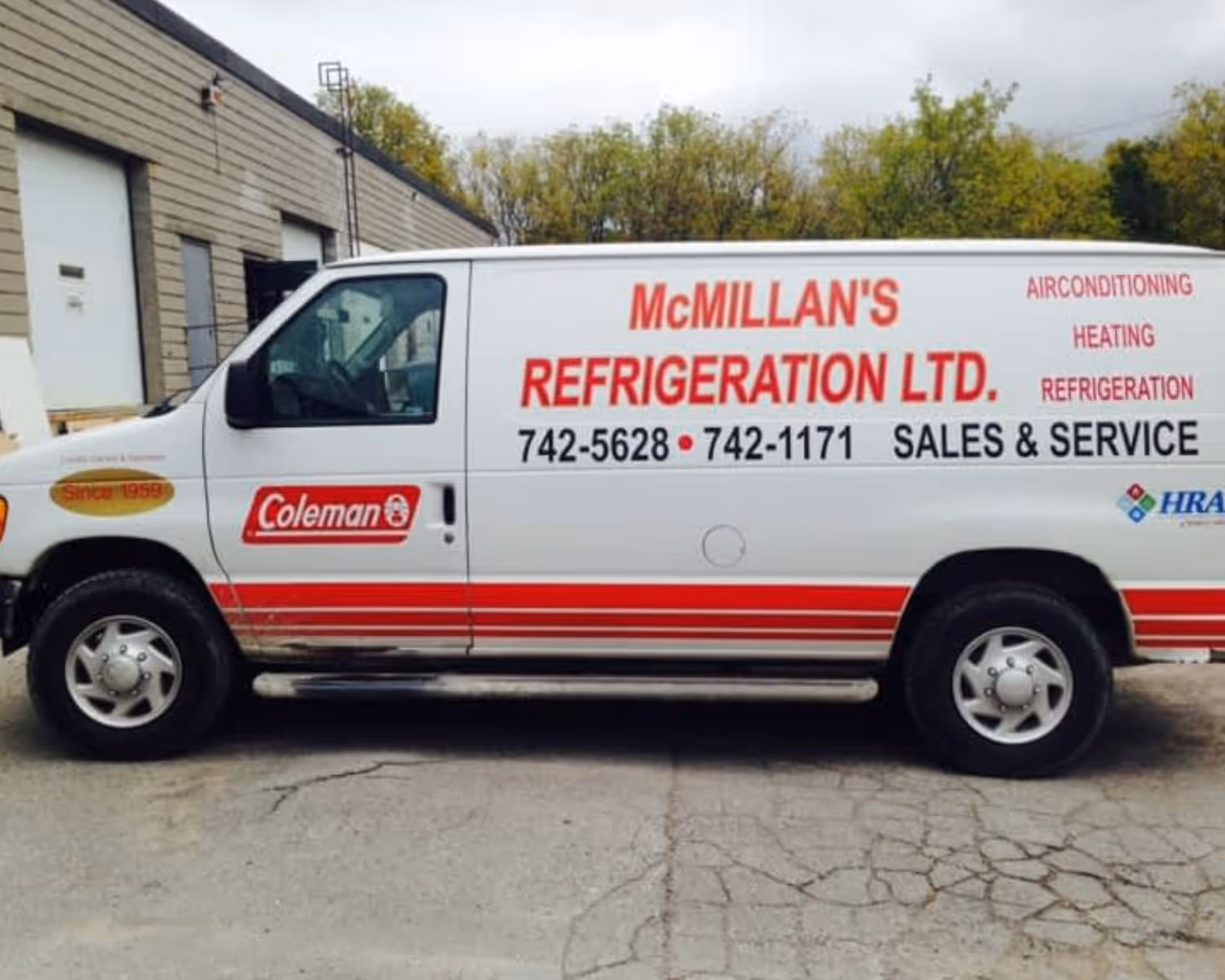 White company van with red stripes featuring McMillan's Refrigeration Ltd. advertising air conditioning, heating, refrigeration, sales, and service with contact numbers.