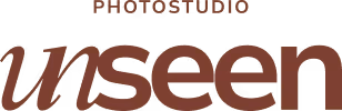 Logo van photostudio Unseen met grote, cursieve letters voor 'unseen' en kleinere hoofdletters voor 'photostudio' erboven.