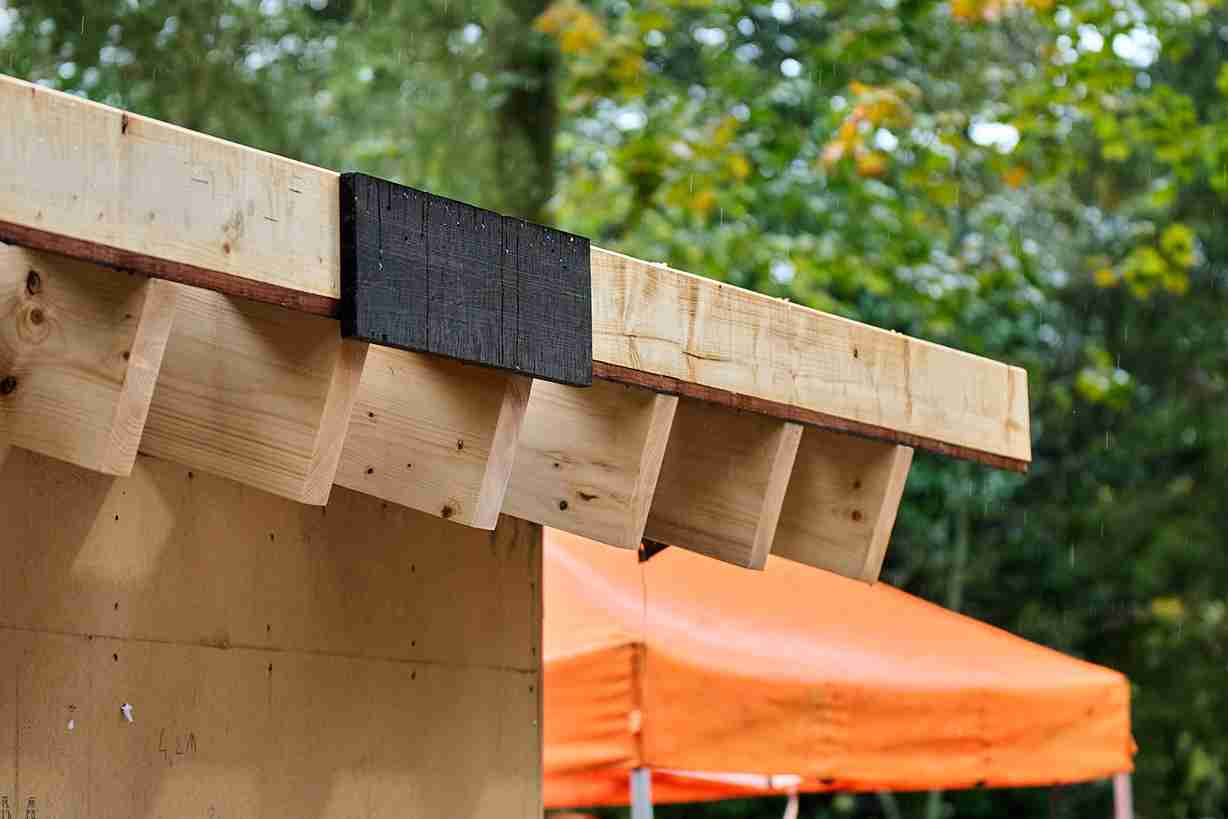 Detail van de houten dakstructuur en balken van een houtskeletbouw in aanbouw buiten