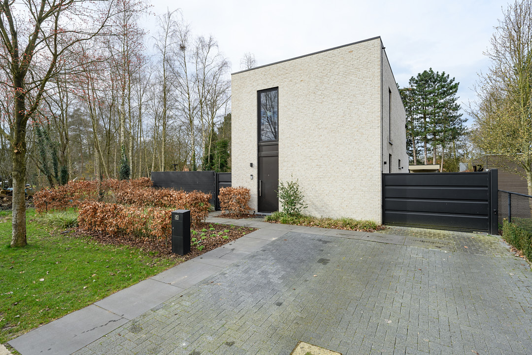 Energiezuinige nieuwbouwwoning in Beerse met witte gevelsteen, plat dak en verharde oprit