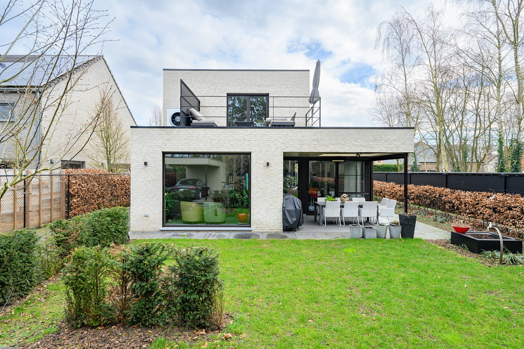 Achtergevel van de woning in Beerse met dakterras, overdekt terras en aangelegde tuin