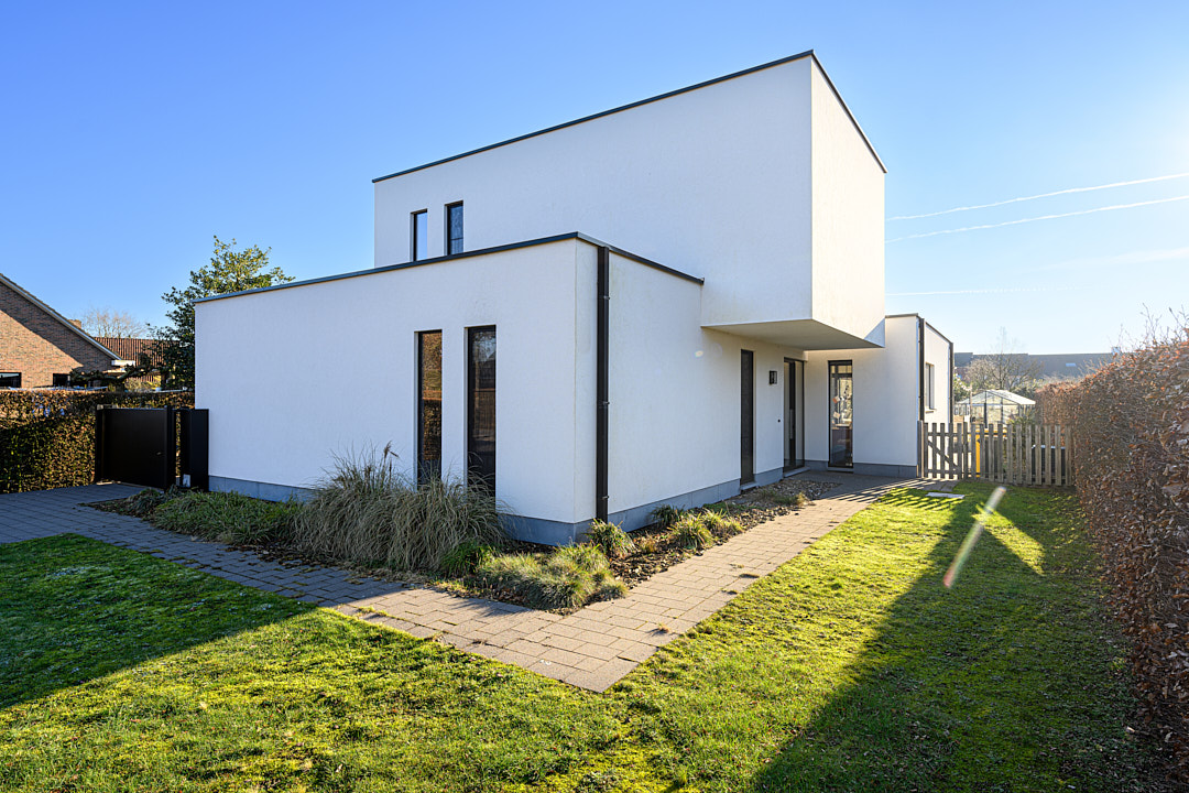 Strakke witte woning met crépi-afwerking en aanbouw na renovatie in Wortel