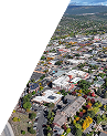 Aerial view of a suburban town with houses, roads, and greenery extending to the horizon.