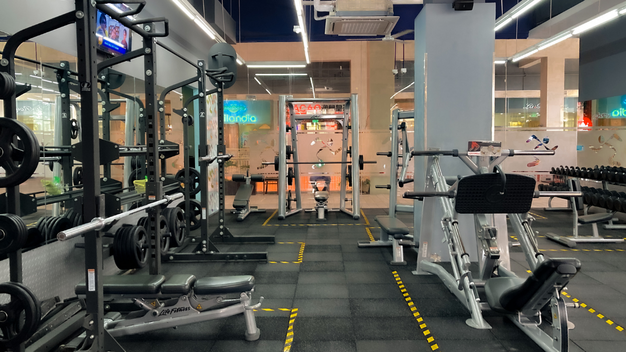 Alt text: Weight machines, benches, and dumbbells inside a gym.