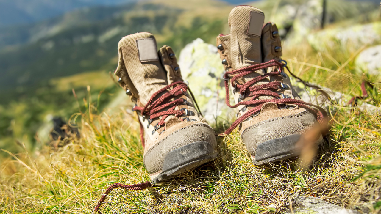 Pair of brown hiking boots resting on a mountain trail