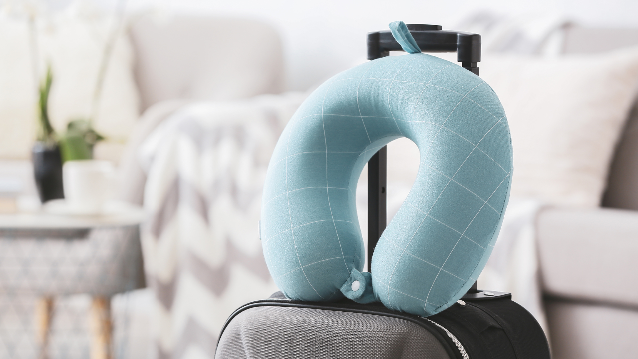 A gray travel pillow beside its storage pouch