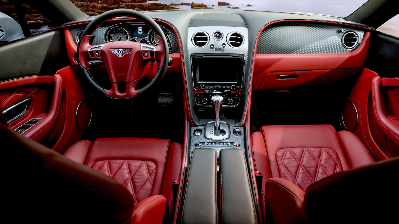 A red and black car interior viewed from the passenger side