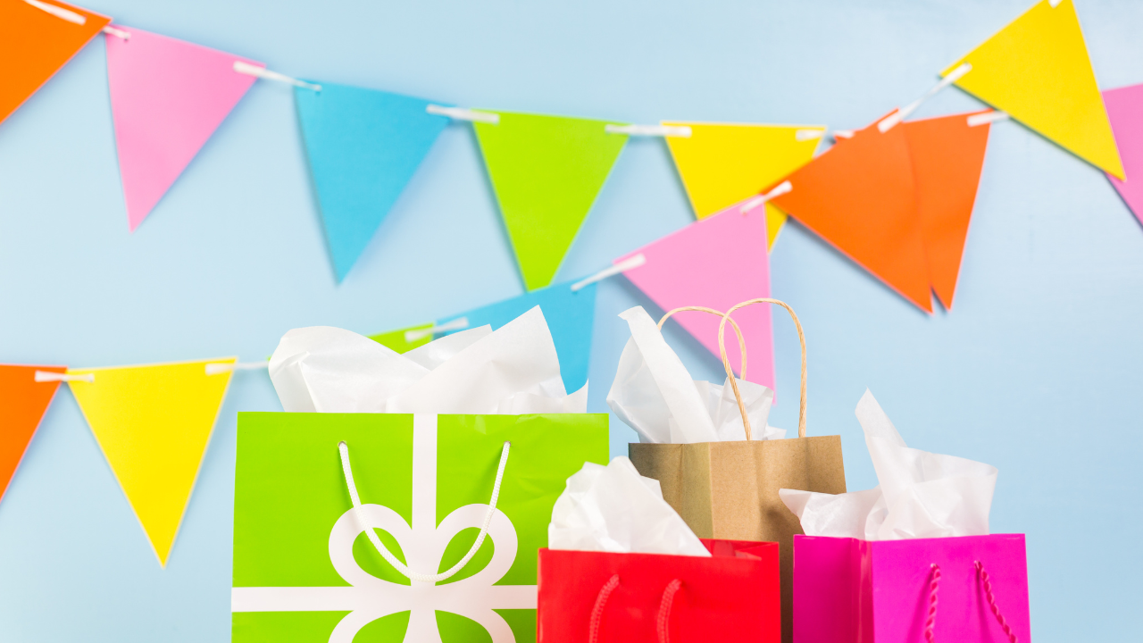 Bright gift bags beneath colorful party bunting