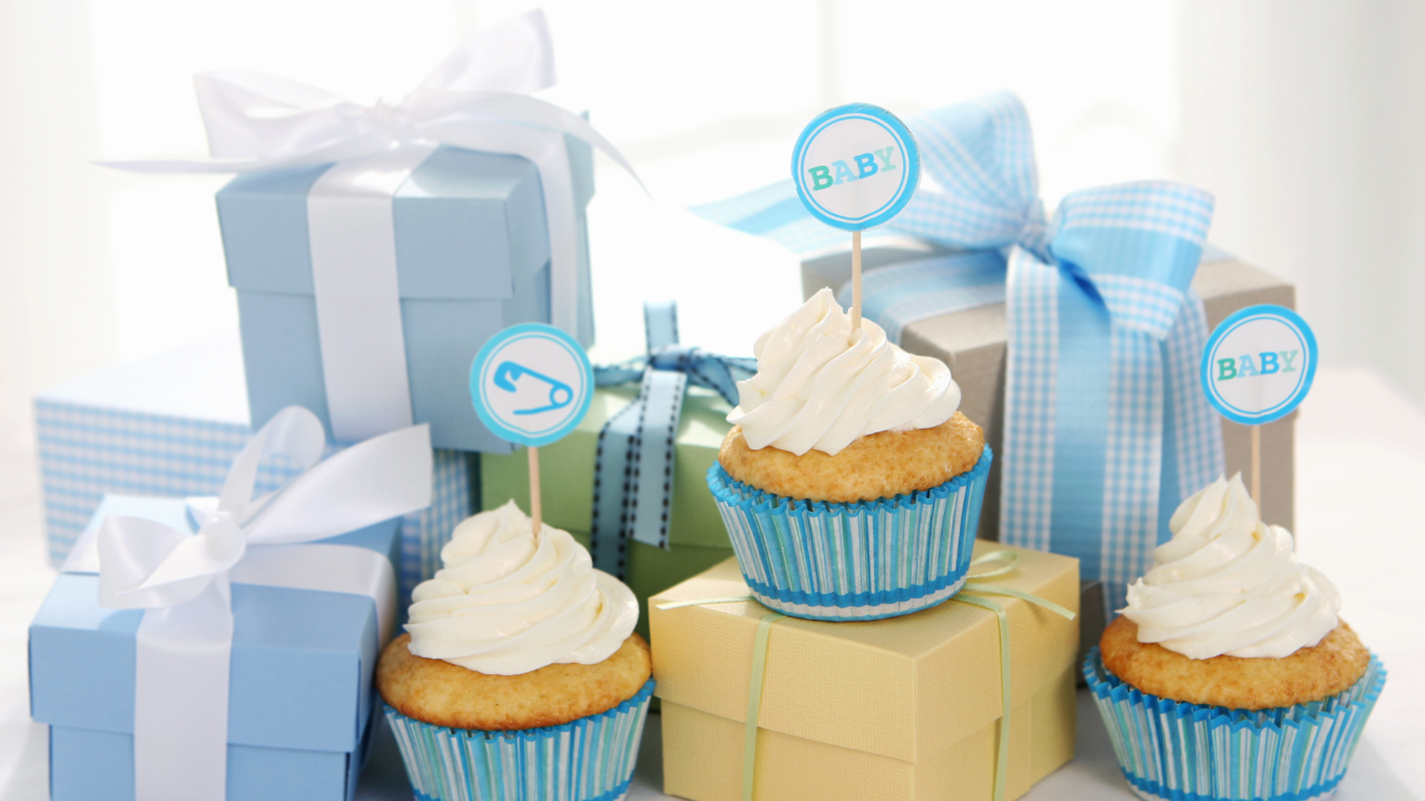 Baby shower cupcakes, toppers, ribbons, and wrapped gifts
