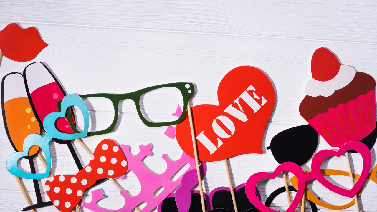 Colorful glasses, lips, hearts, and signs mounted as photo booth props