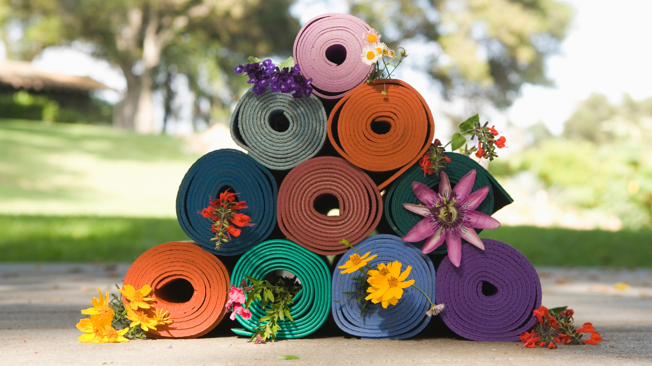 Colorful rolled yoga mats stacked outside