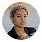 Portrait of a woman with curly blonde hair wearing a black top and gold hoop earrings.