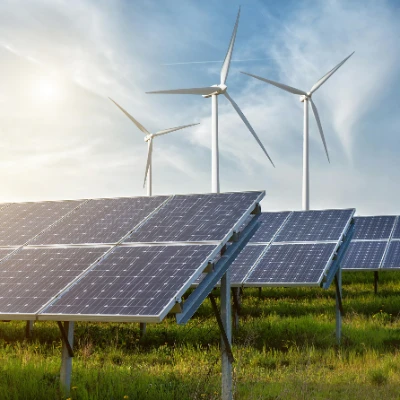 Solar panels and wind turbines out in a rural field on a sunny day