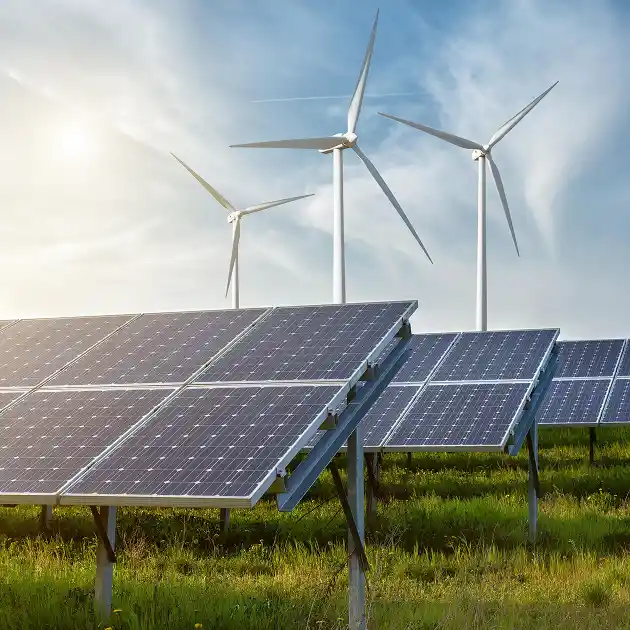 Solar panels and wind turbines out in a rural field on a sunny day