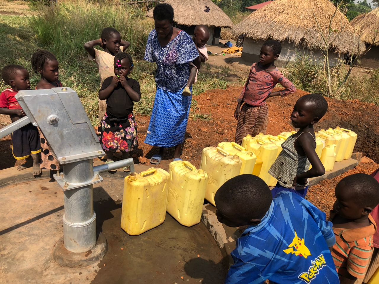 A family filling containers at their new well