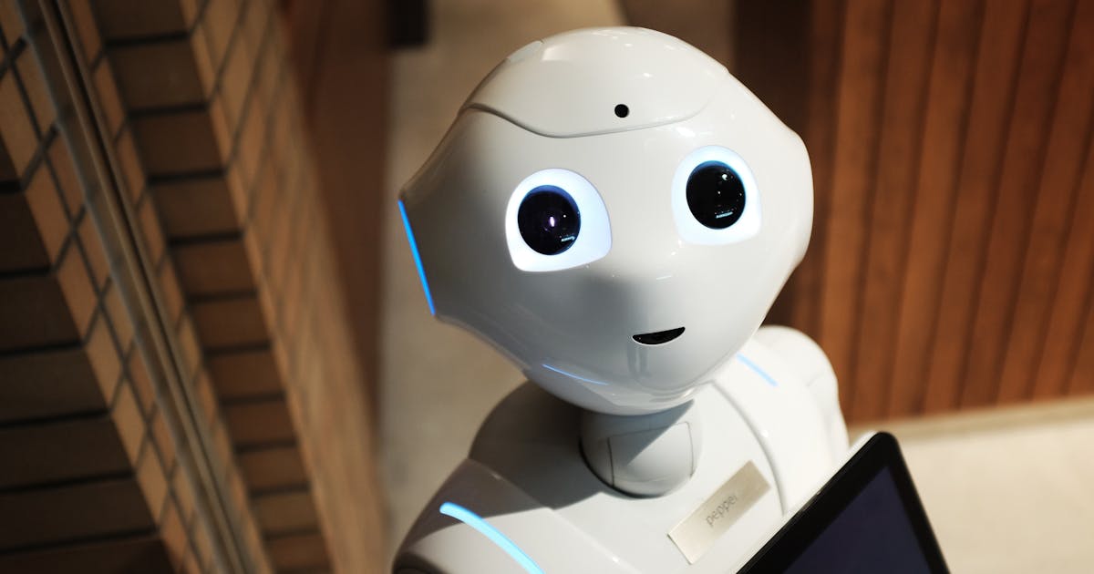 Pepper humanoid robot with blue eyes in office reception