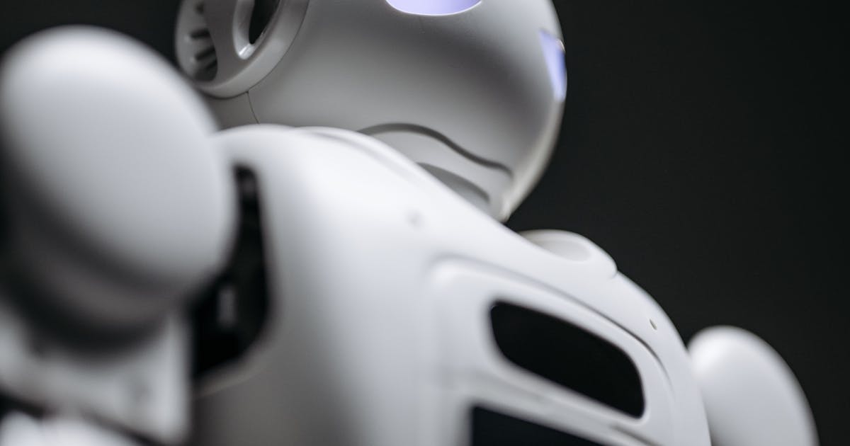 Tesla Optimus white humanoid robot profile view close-up