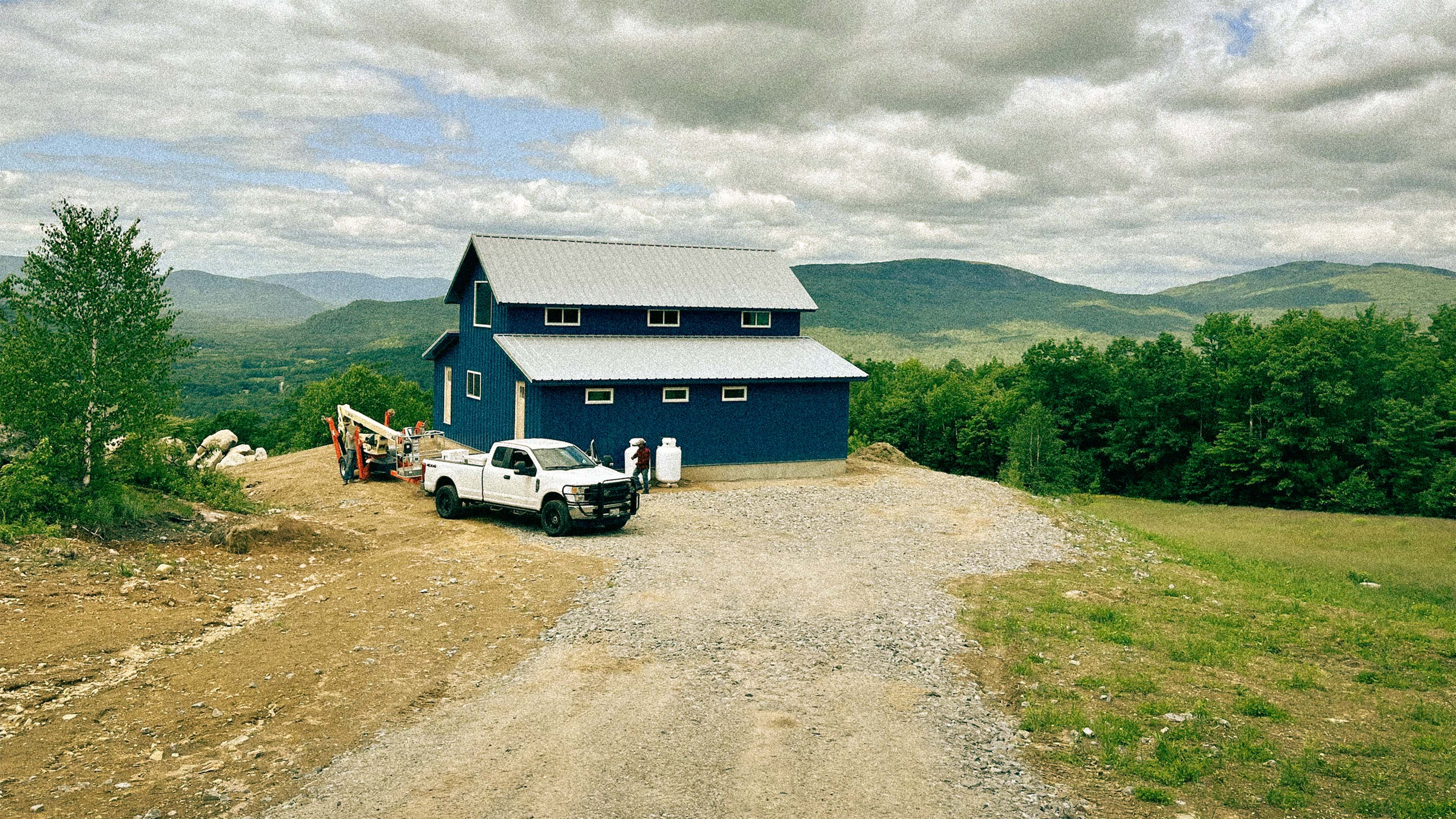 Steel barndominium home with a metal roof on a rural Maine lot