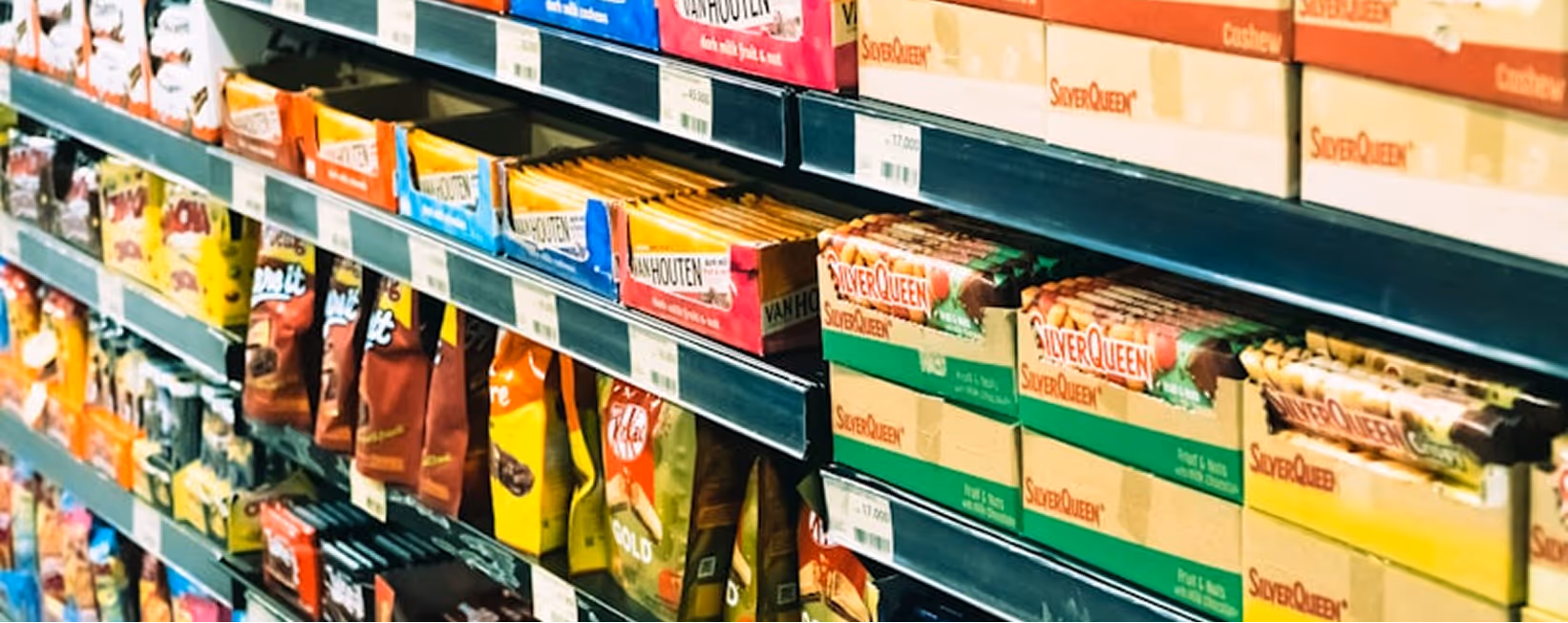 Shelves stocked with various boxed and bagged confectionery products including SilverQueen chocolates in a store.